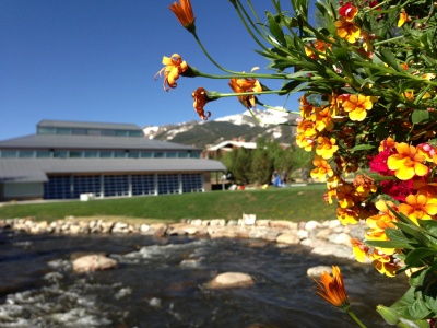 Summer view of the Blue River and Breckenridge Riverwalk Center and events lawn